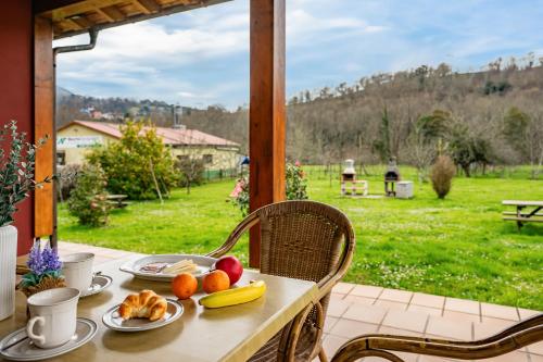 a table with fruit on it on a porch at Apartamentos Les Cuartes in Cangas de Onís
