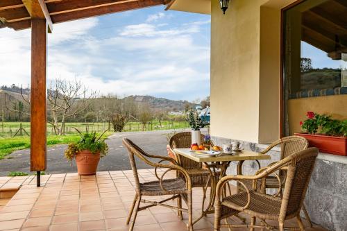a table and chairs on a patio with a view at Apartamentos Les Cuartes in Cangas de Onís