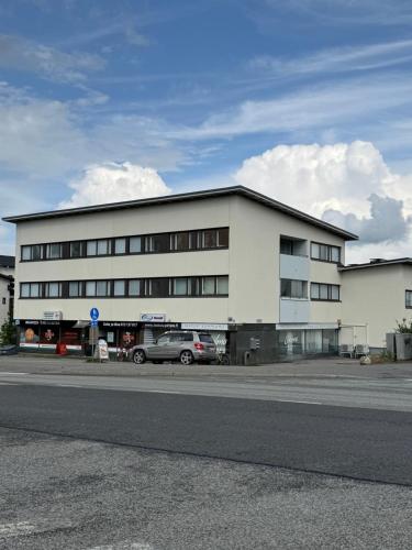 a white building with a car parked in front of it at Two-room apartment near the hospital in Joensuu