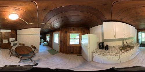 a kitchen with a wooden ceiling and a table in a room at Dune Climb Inn in Empire