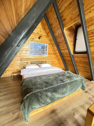 a bedroom with a bed in a wooden cabin at zevgar bungalov hotel in Ayvacık