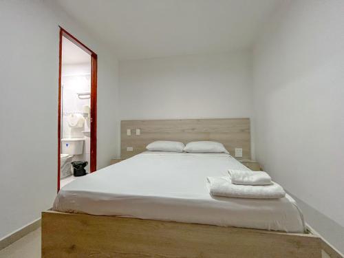 a bedroom with a large bed and a mirror at NEÓN TOLIMA - Hotel en Zona Centro de Ibagué - Recepción y Atención Digital 24H in Ibagué
