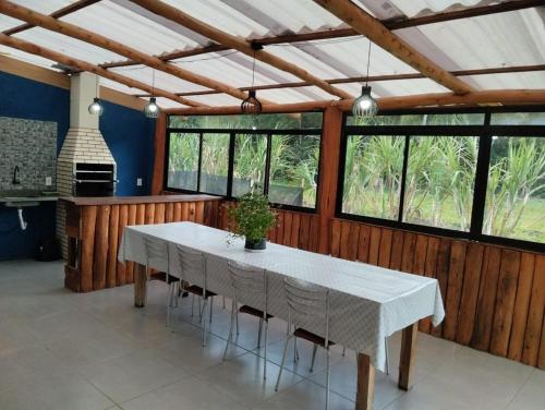 a dining room with a white table and some windows at Spaço Terra hospedagem in Domingos Martins