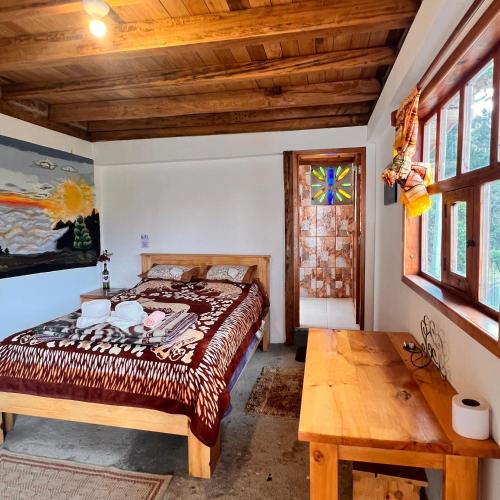 Un dormitorio con una cama y una mesa de madera. en Hostal Doña Clarita Inn, en Chugchilán