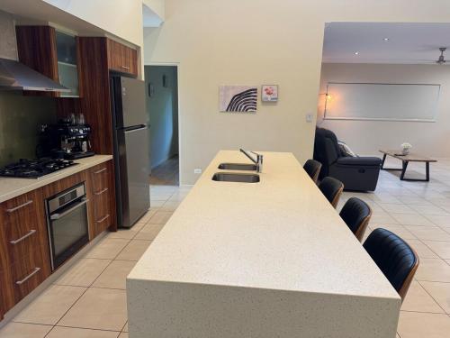 a kitchen with a counter top and a living room at Entire 4 bedroom home in Palm Cove in Palm Cove