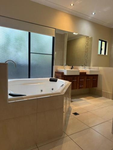 a large bathroom with a tub and a sink at Entire 4 bedroom home in Palm Cove in Palm Cove