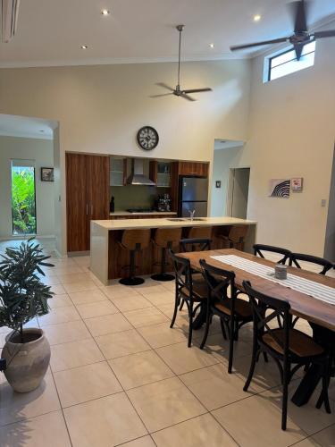 a kitchen with tables and chairs and a clock on the wall at Entire 4 bedroom home in Palm Cove in Palm Cove
