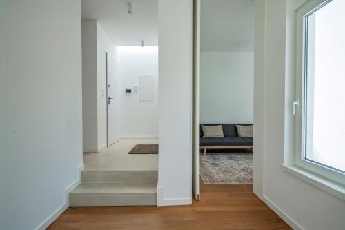 un corridoio con pareti bianche e scale con finestra di The Hideway, Peaceful Energy & Modern Comfort! a Santo Isidoro
