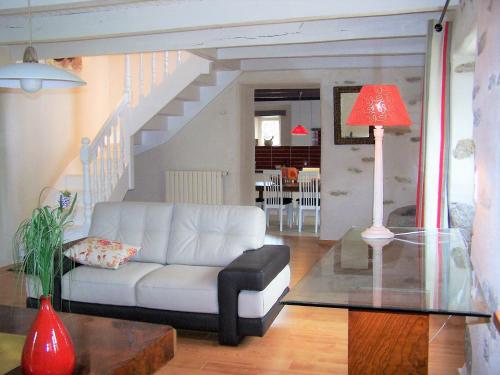 a living room with a white couch and a staircase at Holiday Home in Huelgoat near Monts d'Arrée in Huelgoat