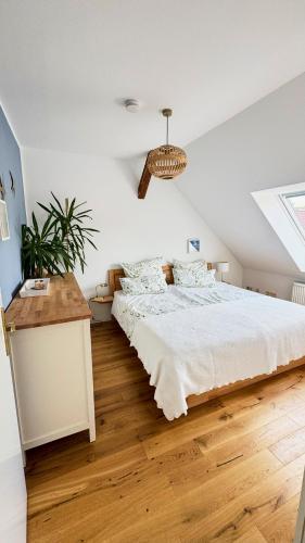 a white bedroom with a bed and a table at Luxuriöse Ferienwohnung mit 3 Schlafzimmern in Tremsbüttel