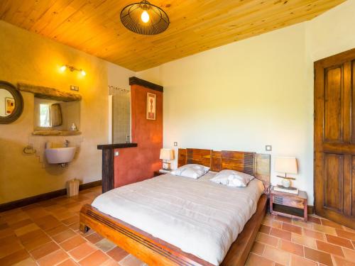 a bedroom with a bed and a bathroom with a sink at Mazeyrolles Forest Escape in Mazeyrolles