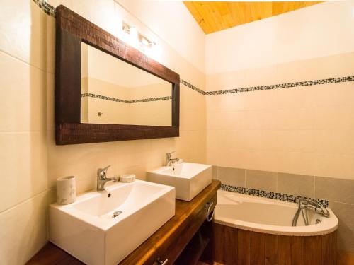 a bathroom with two sinks and a tub and a mirror at Mazeyrolles Forest Escape in Mazeyrolles