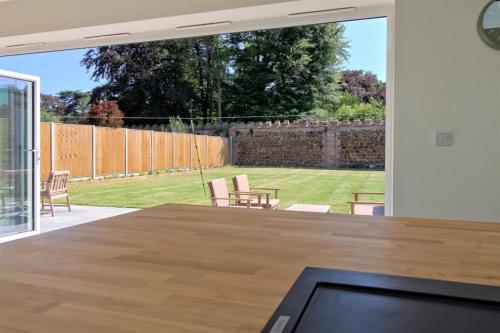 a living room with a table and a large window at Detached Home Near Kings Lynn in North Runcton