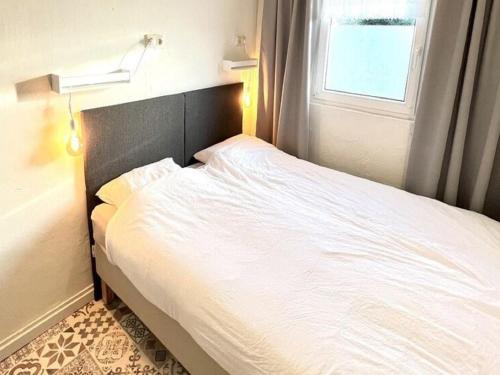 a white bed in a room with a window at Farmhouse in Nederweert near Canal Trails in Ospel