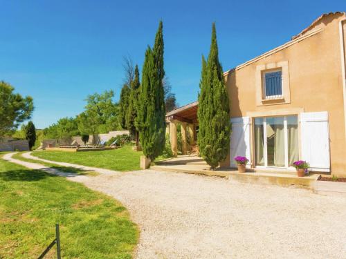 a house with trees next to a gravel driveway at Holiday Home in Loupia with Private Pool in Loupia
