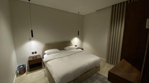 a bedroom with a bed with white sheets and pillows at روز فيلا in Al Madinah