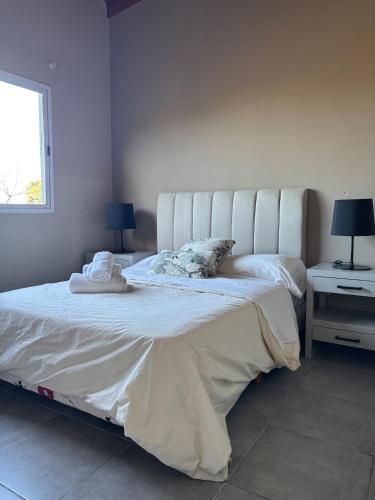 a bedroom with a large white bed with a window at Altos de Pinamar in Ostende