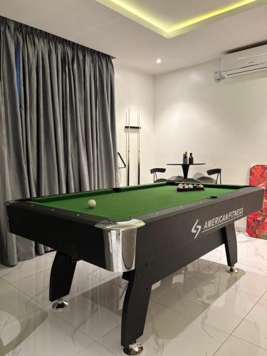 a billiard table in a living room with afits at LB Homes in Mama