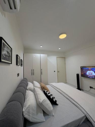 MamaにあるLB Homesのベッドルーム(大型ベッド1台、枕、テレビ付)