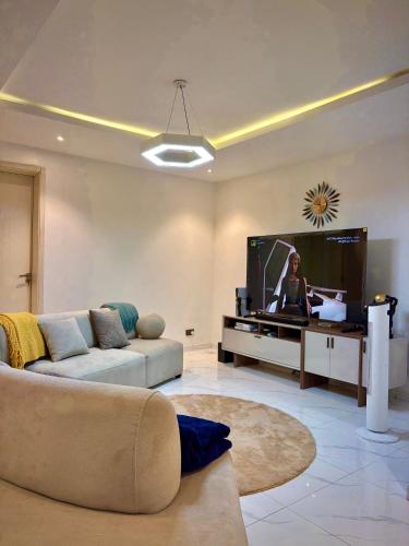 a living room with a couch and a flat screen tv at LB Homes in Mama
