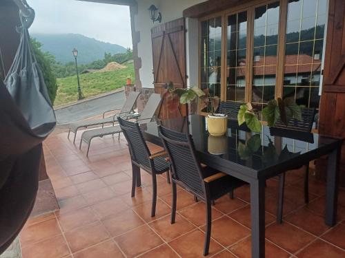 a black table and chairs on a balcony with a view at Casa Rural Amazonas in Sumbilla