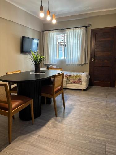 a living room with a table and a bedroom at Altos de Pinamar in Ostende