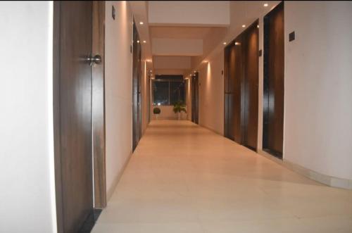 an empty corridor of a building with doors and a hallway at Hotel Ten in Vapi