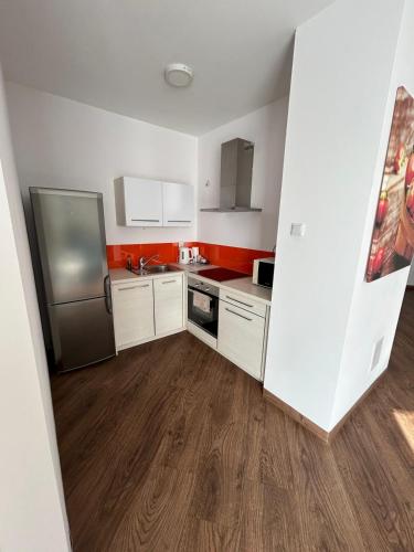 a kitchen with white cabinets and a stainless steel refrigerator at Cube Apartamenty in Lublin