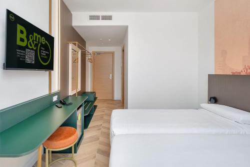 a hotel room with a bed and a desk and a bed sidx sidx at B&B HOTEL Treviso Al Fogher in Treviso