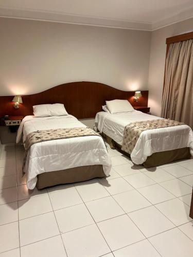 a hotel room with two beds in a room at Anacã SC in São Carlos