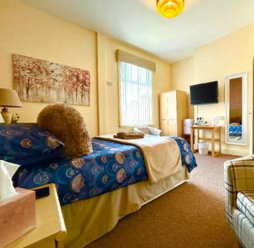 a bedroom with a bed with a blue comforter at The Copplehouse in Southport