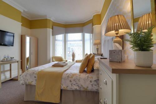 a bedroom with a bed and a desk with a plant on it at The Copplehouse in Southport