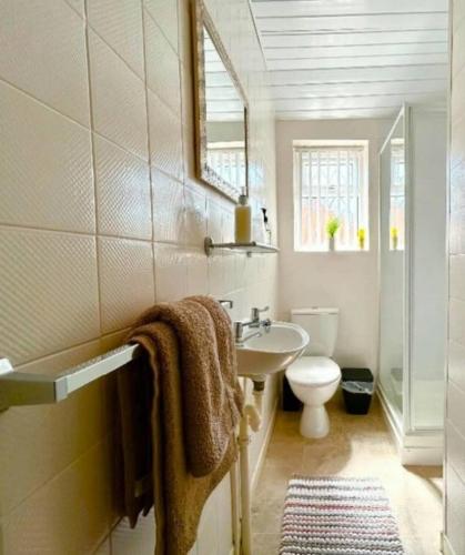 a bathroom with a sink and a toilet and a mirror at The Copplehouse in Southport