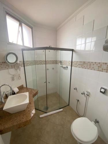 a bathroom with a shower and a toilet and a sink at Anacã SC in São Carlos