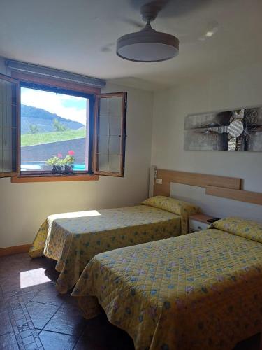 a bedroom with two beds and a window with a view at Casa Rural Amazonas in Sumbilla