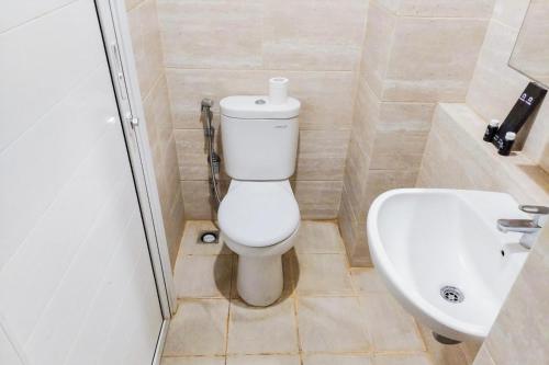 ein Badezimmer mit Toilette und Waschbecken in der Unterkunft Studio Apartment Springwood By LyaRoom in Warungmangga