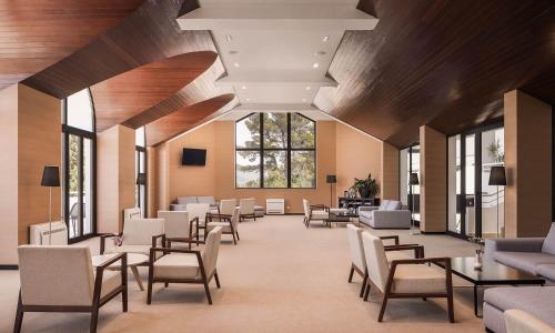 a waiting room with chairs and tables and a large window at Aminess Younique Liburna Hotel in Korčula