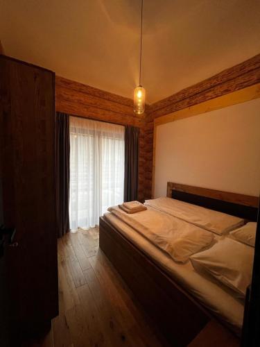 a bedroom with a large bed and a window at MoNa chalet in Pavčina Lehota
