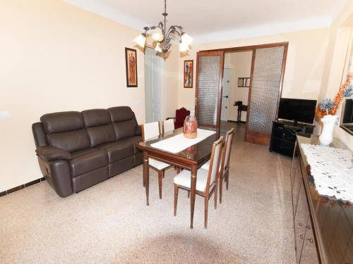 a living room with a table and a leather couch at Holiday Home in St Pere Pescador with Pool in Sant Pere Pescador