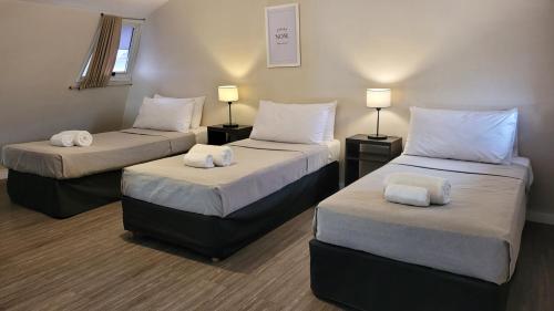 a room with three beds with white pillows at Soltigua Apart Hotel Mendoza in Mendoza