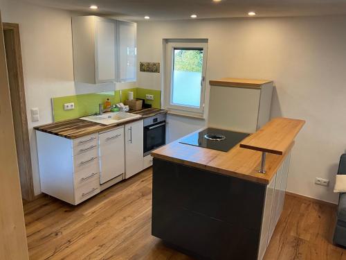 a kitchen with white cabinets and a counter top at Ferienwohnung in der Au in Unterwössen