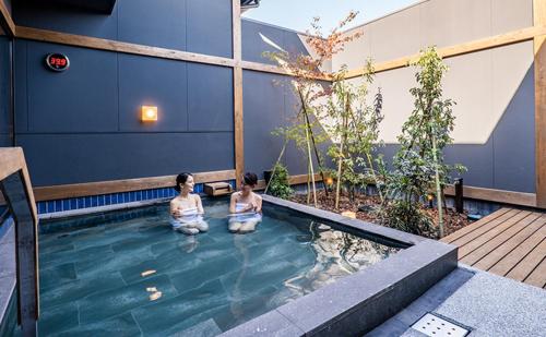 two people sitting in a pool of water at Joy House in Imari