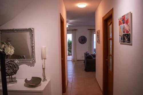 a hallway with a living room with a mirror on the wall at Cas Forner in Cala Pi
