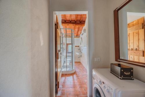 a laundry room with a washing machine and a mirror at Apartment with view and garden - Quercia in Ghizzano
