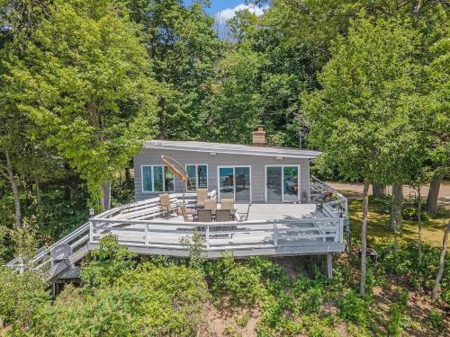 een huis met een groot terras met stoelen erop bij Private Beachfront Lake Michigan Getaway in West Olive