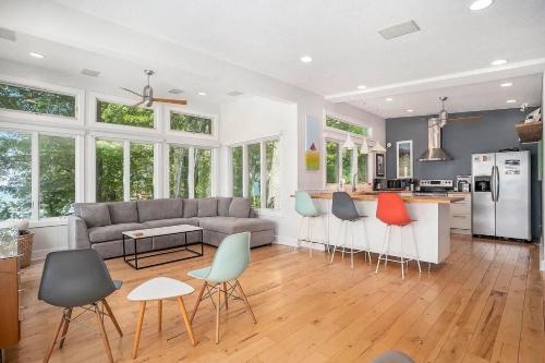 een keuken en een woonkamer met een bank en stoelen bij Private Beachfront Lake Michigan Getaway in West Olive