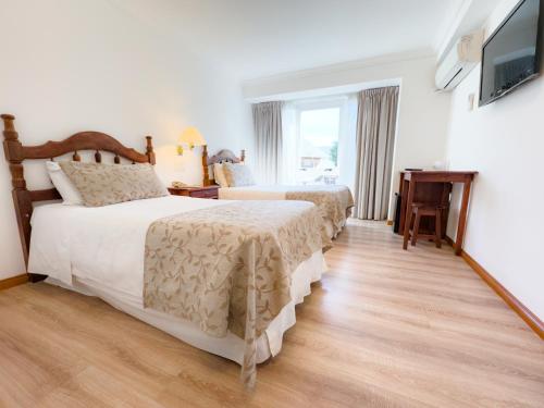 a hotel room with two beds and a television at Patagonia Plaza Hotel in San Martín de los Andes