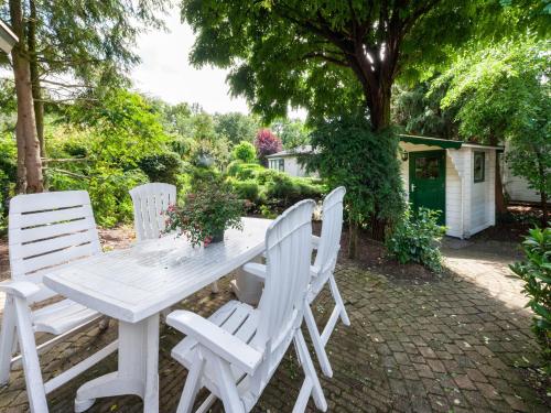 a white picnic table and four white chairs at Chalet in Stegeren with Pool and Gardens in Stegeren
