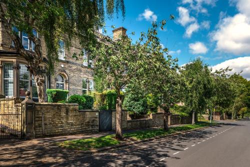 a tree lined street in front of a house at Edgerton Apartments in Huddersfield