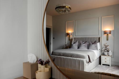a bedroom with a bed and a mirror at Edgerton Apartments in Huddersfield